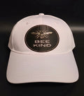 White cap with a honeybee graphic and BEE KIND message