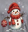 Christmas snowman in red Santa hat and plaid scarf holding a holiday ornament on a gray T-shirt