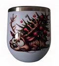 Playful reindeer with evergreen branches and red ornaments on a white wine tumbler